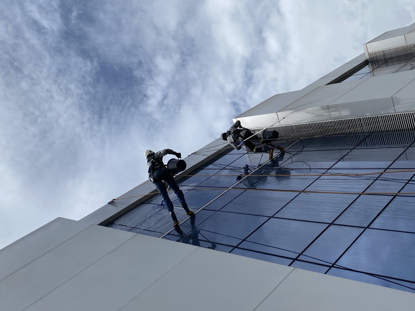 Técnico em rapel limpando pele de vidro de torre corporativa em Brasília